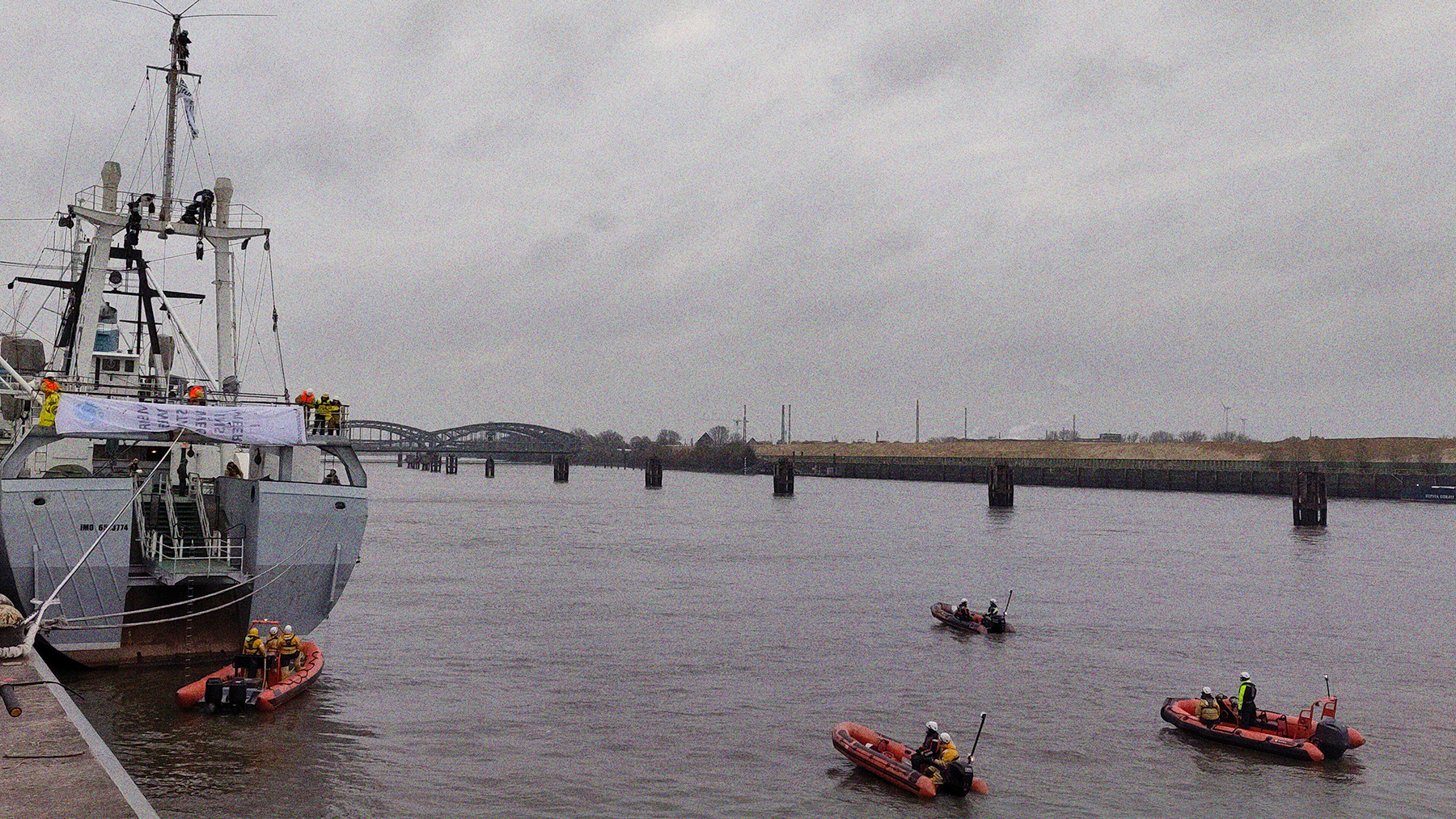 Training von Greenpeace 2022. Auf dem Wasser neben und hinter der angelegten Stubnitz sind mehrere Rettungsboote.