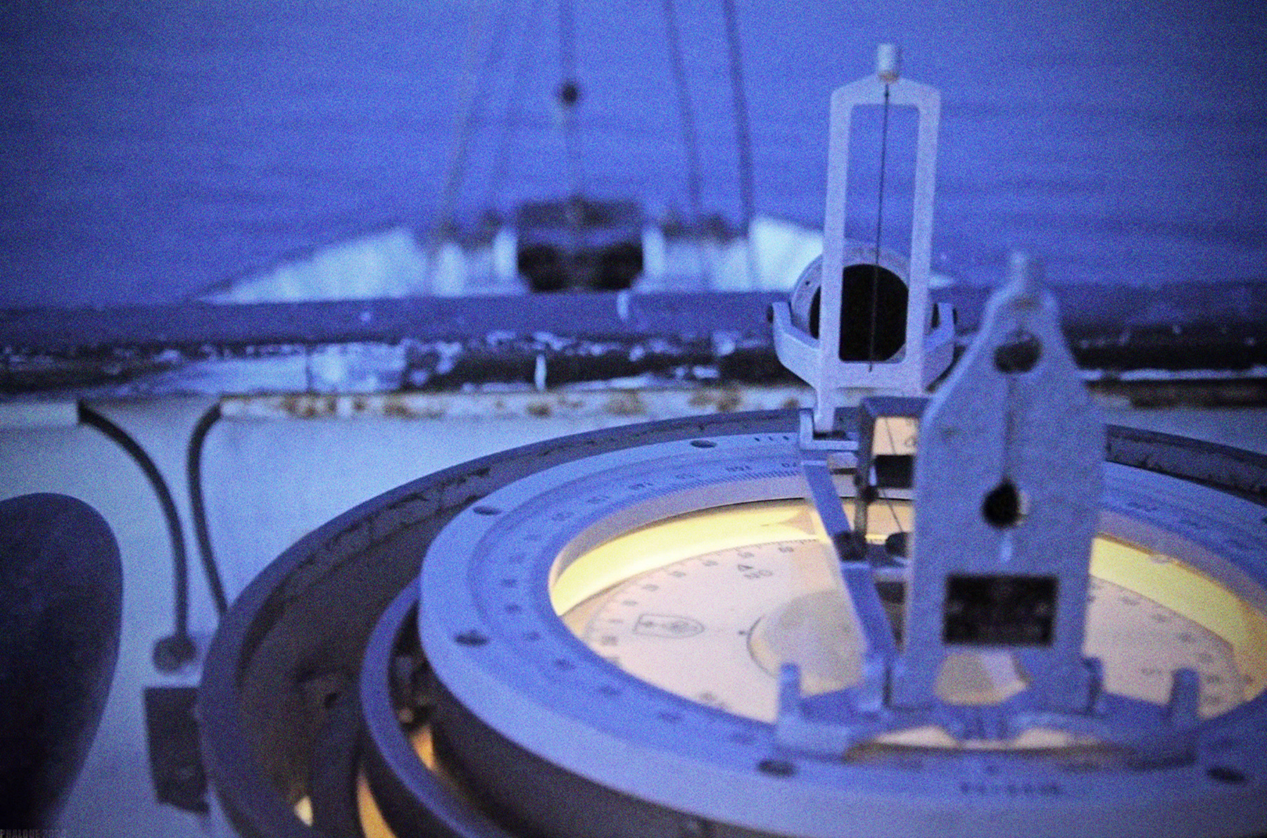 Im Vordergrund der große Kompass auf dem Peildeck. Im Hintergrund das Bug des Schiffes und Wasser.