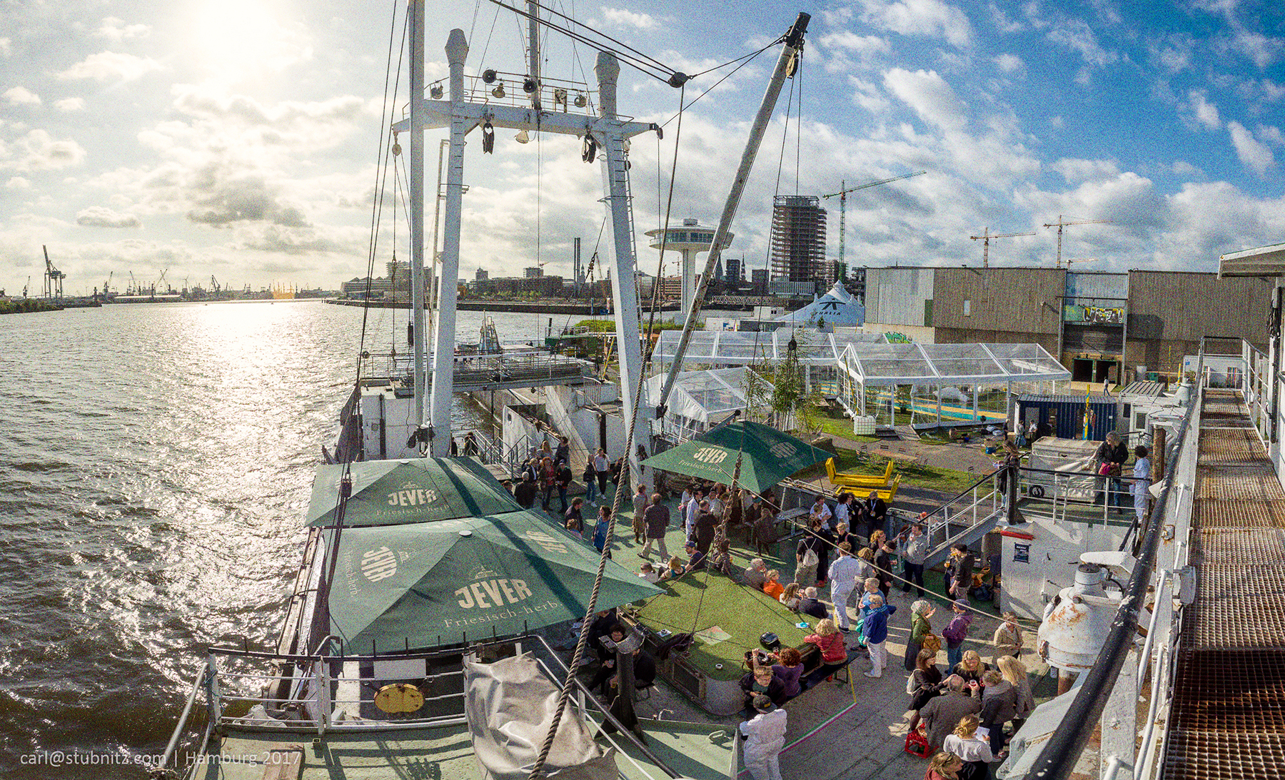 Die Stubnitz als Teil des Theater der Welt 2017 vor dem ehemaligen Afrikaterminal im Hamburger Baakenhafen. Auf dem Achterdeck sind Sonnenschirme und einige Menschen.