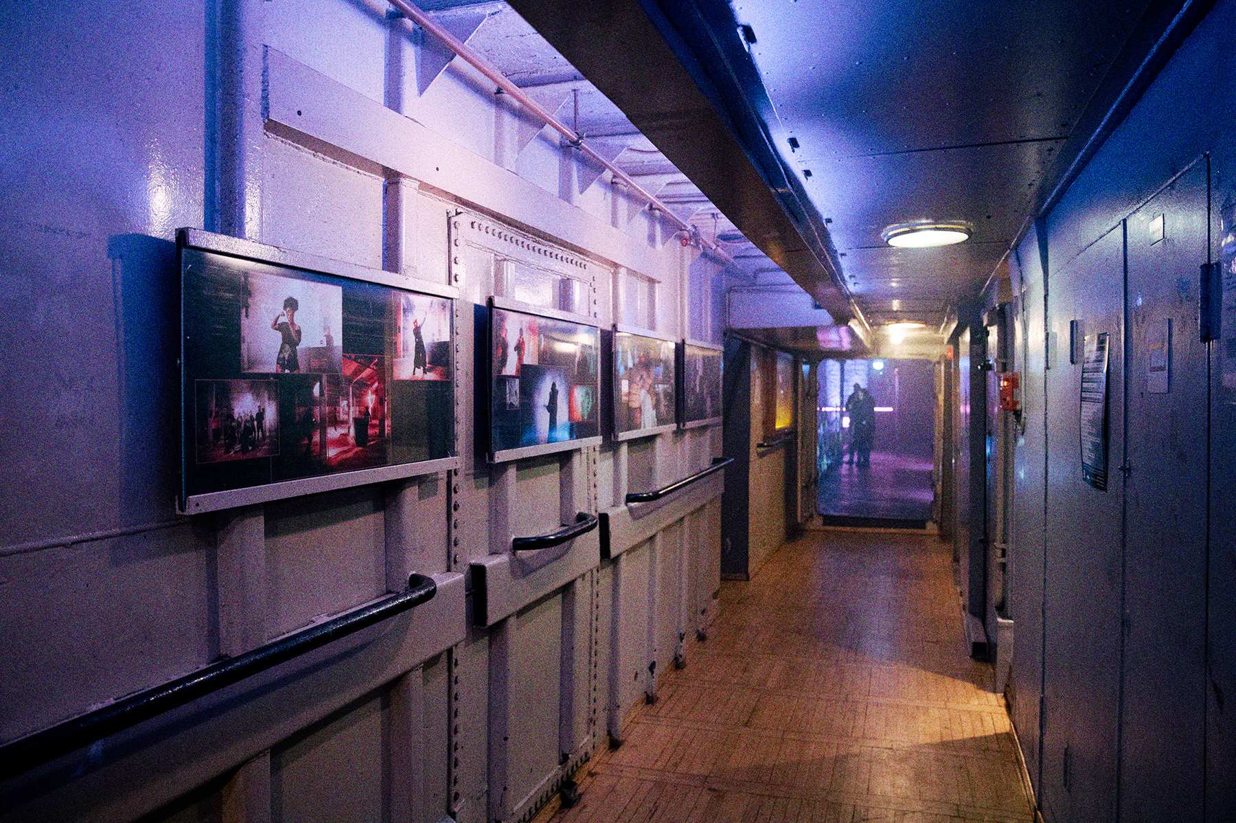 Der Betriebsgang der Stubnitz. An den Wänden hängen Bilderrahmen mit Fotos.