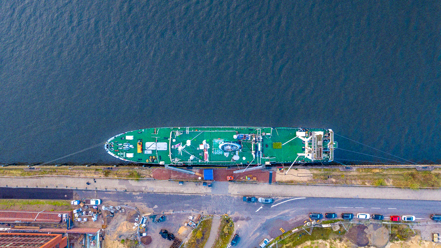 Die Stubnitz an ihrem aktuellen Liegeplatz an den Elbbrücken. Fotografiert aus der Vogelperspektive. Oben im Bild das Wasser, mittig das grüne Deck der Stubnitz von oben, unten der Kirchenpauerkai.