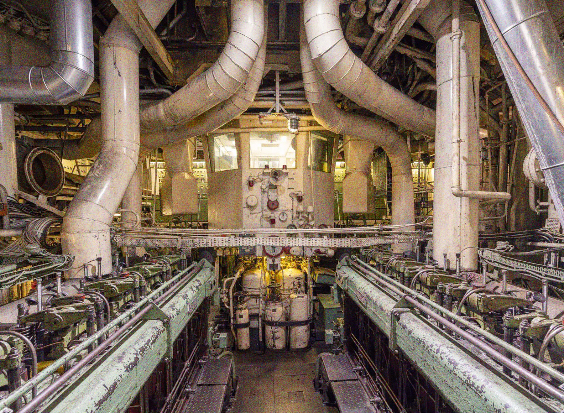 Der Maschinenraum der Stubnitz. Auf dem Bild sind mehrere Abgasrohre, Zylinderköpfe, Messeinrichtungen sowie der Leitstand zu sehen.