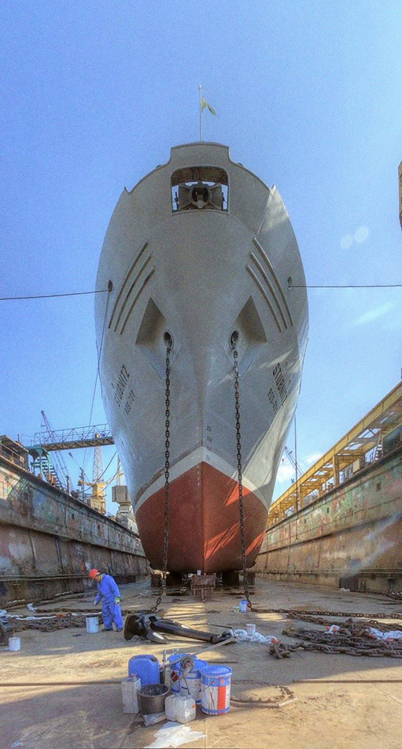 Die Stubnitz im Trockendock der Norderwerft. Jesus steht vor dem Schiff und lackiert die Ankerketten.