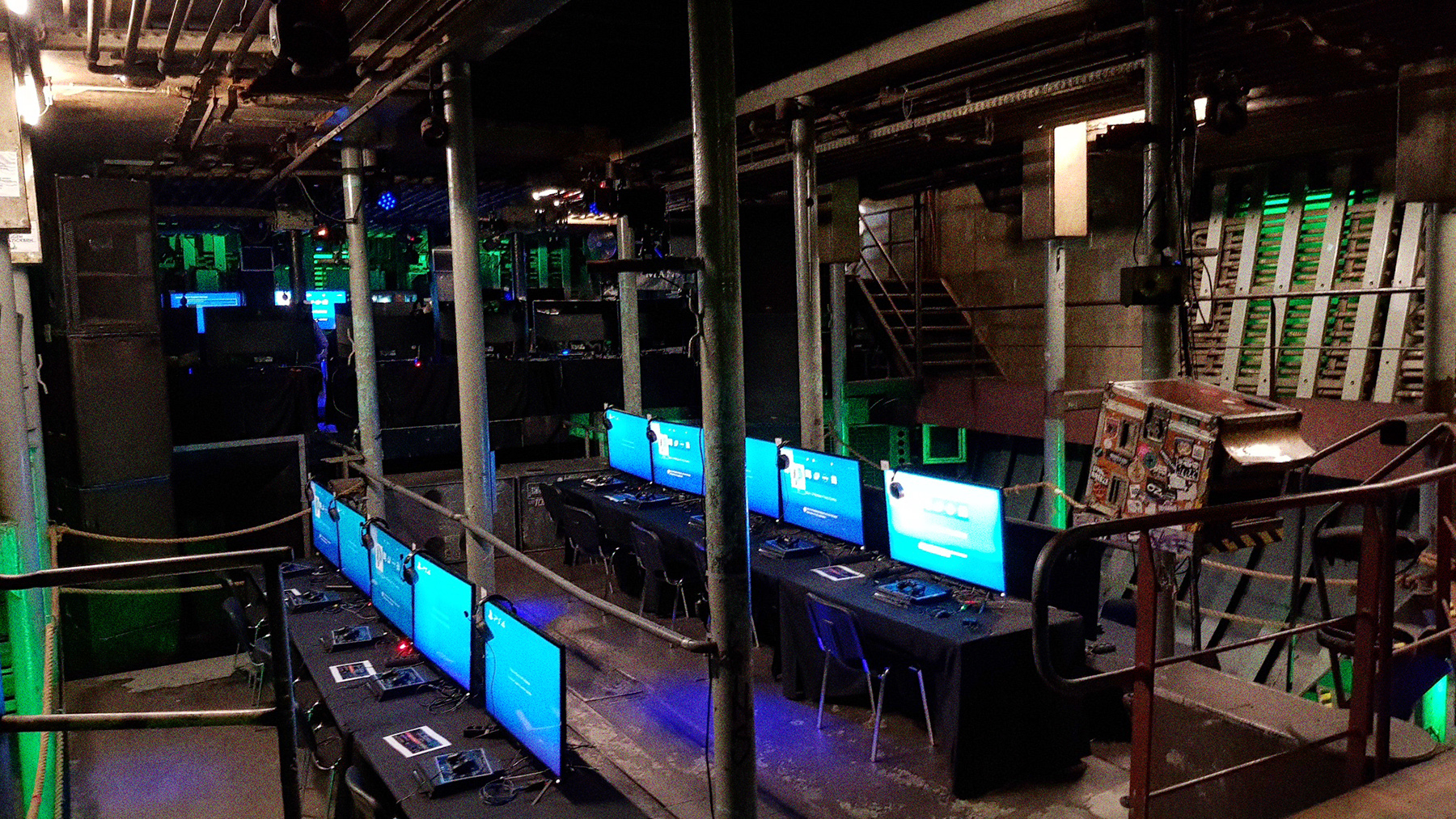 Eine Game Convention in Laderaum 4. Auf der Tanzfläche stehen in mehreren Reihen schwarze Tische mit blau leuchtenden Bilschirmen.