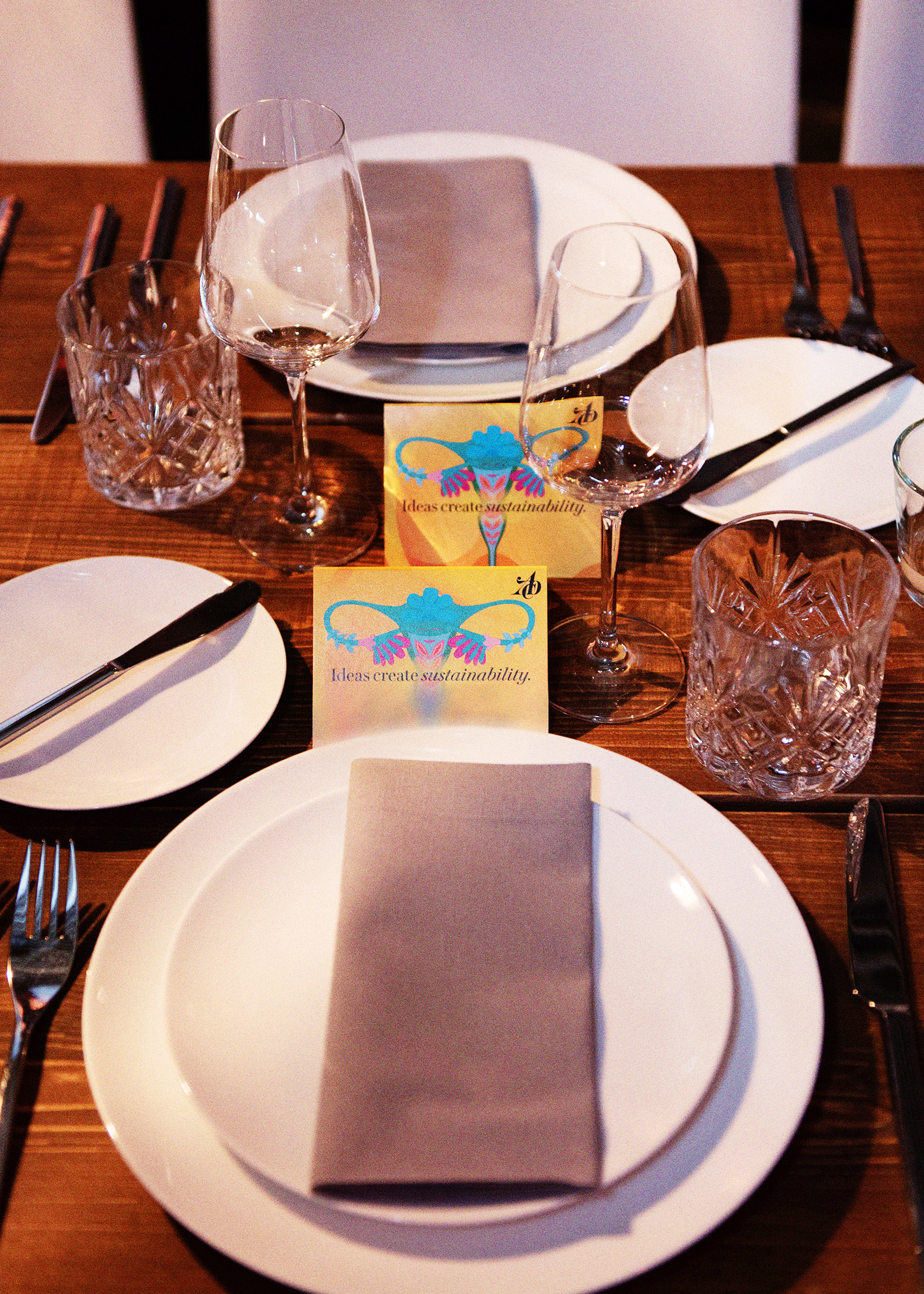 Ein Tischgedeck auf einer Tafel in Laderaum 1. Mehrere Teller und Gläser sind einheitlich angeordnet. Eine Karte mit der Aufschrift "Ideas create sustainability" steht hinter den Tellern.